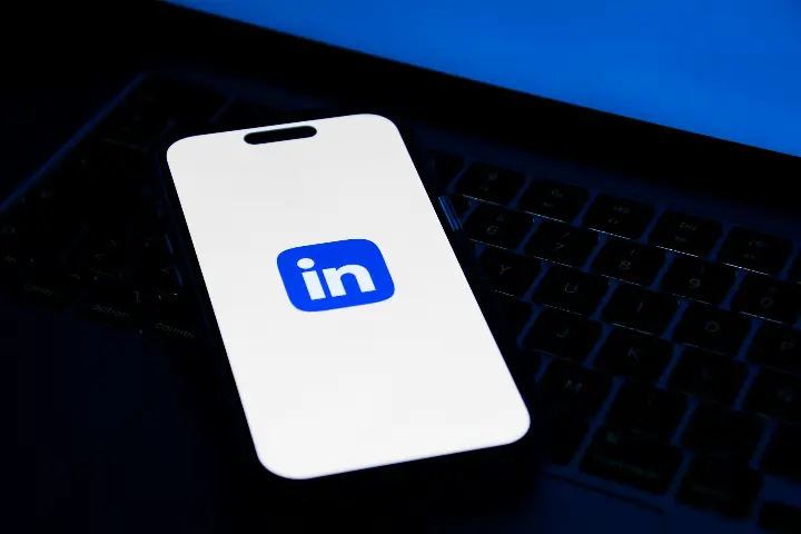 a phone sitting on top of a laptop computer -Best LinkedIn Marketing Strategies for 2024 Onwards